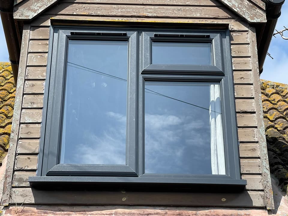 Anthracite grey casement window in a timber-clad dormer