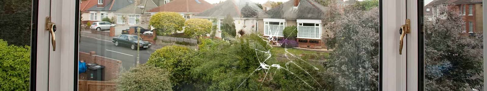Cracked double glazed window pane looking out onto a street