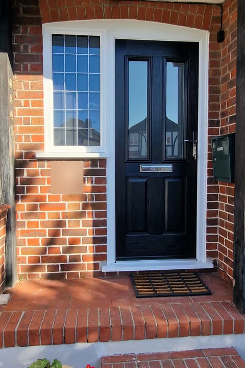 Black front door with an arched side window under a porch