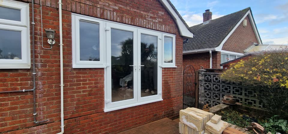 After: new white French doors and side windows in the same wall
