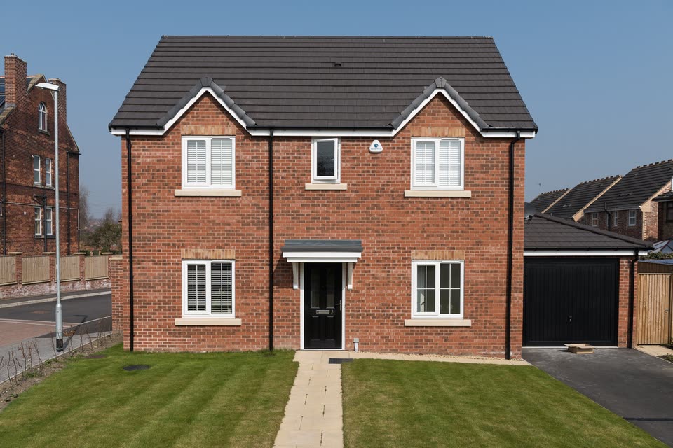 New brick house with white uPVC windows and a black front door