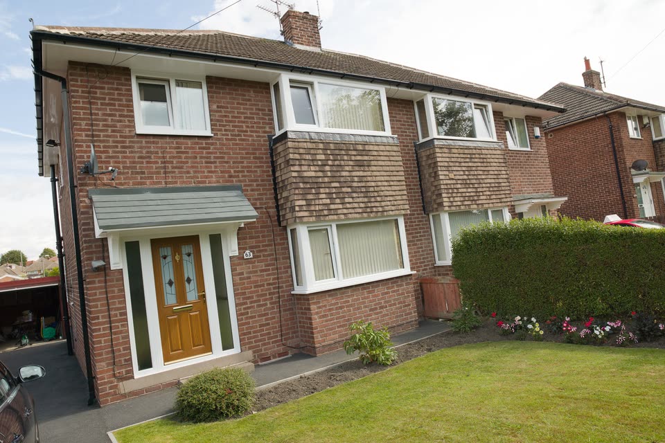 Semi-detached brick house with white uPVC windows and an oak effect front door