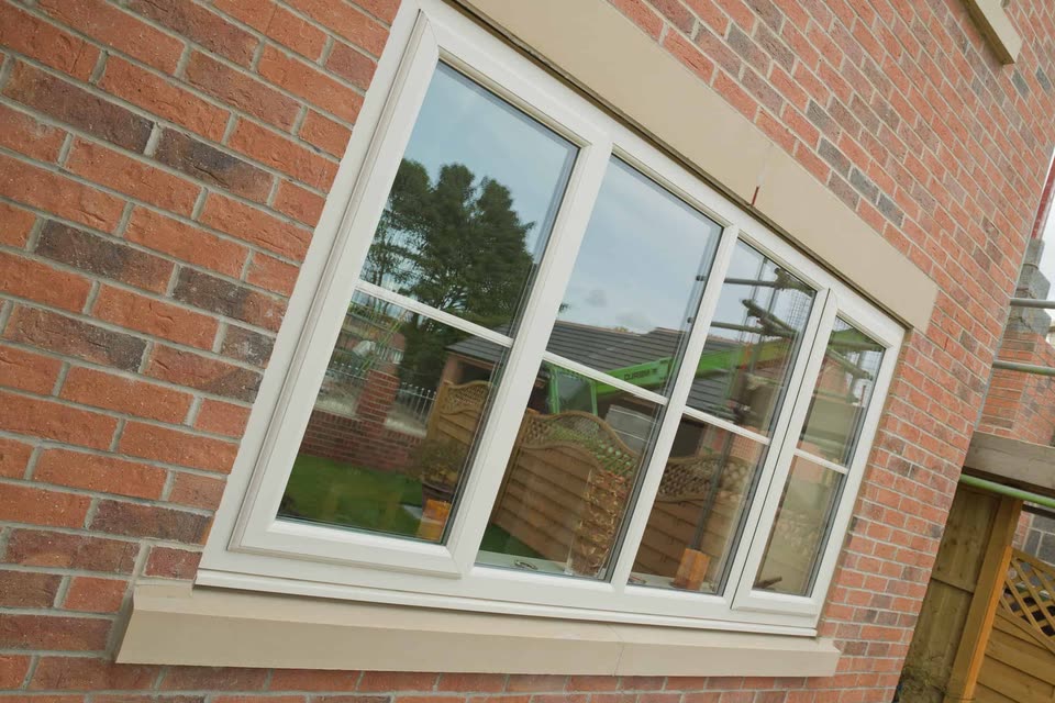 White uPVC casement window with Georgian bars in a brick wall